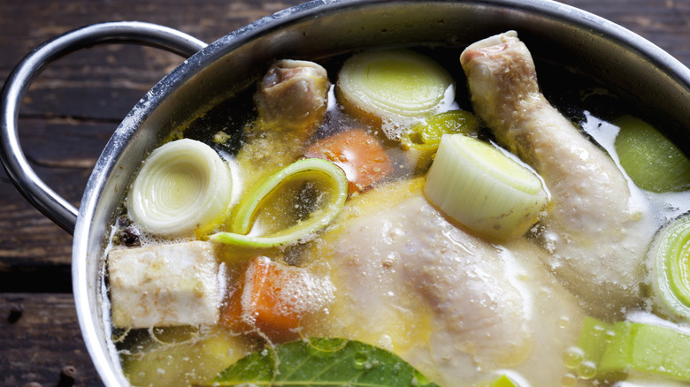 Chicken soup in a pot with chicken bones