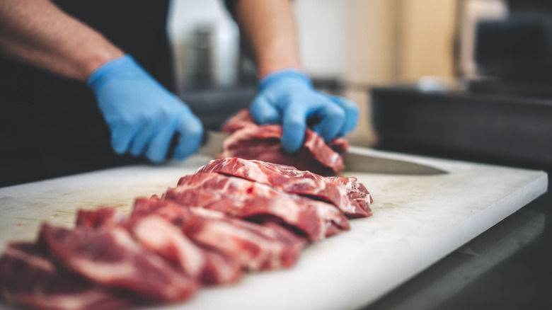 Person slicing raw beef