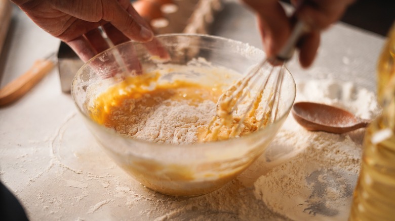 Hands whisking batter