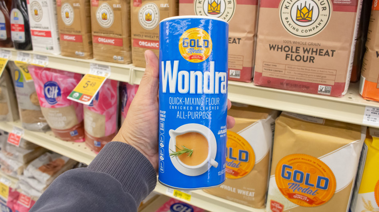 Holding a canister of Wondra flour inside a grocery store