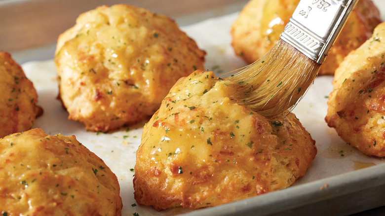 brush buttering cheddar biscuits