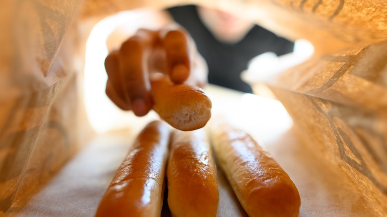 person reaching for breadsticks