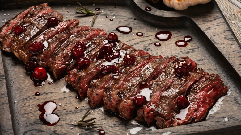 Sliced steak garnished with cranberries