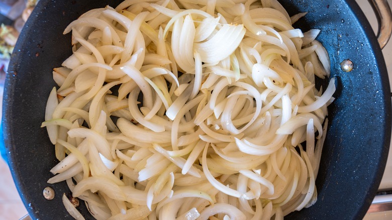 Sliced onions in a dark pan