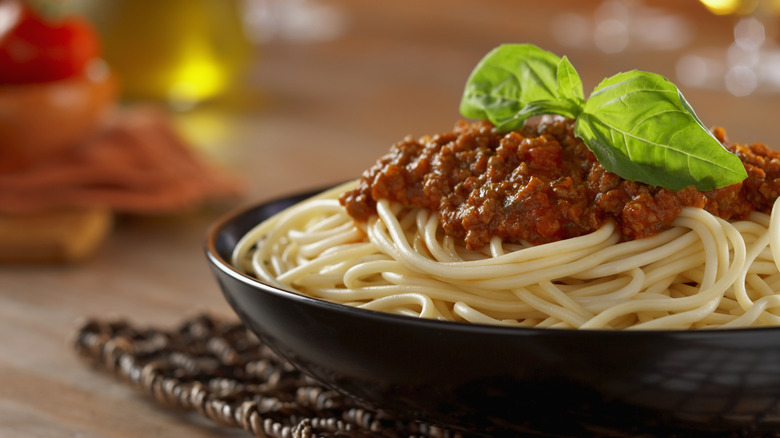 Close up of. tomato sauce on spaghetti with piece of basil