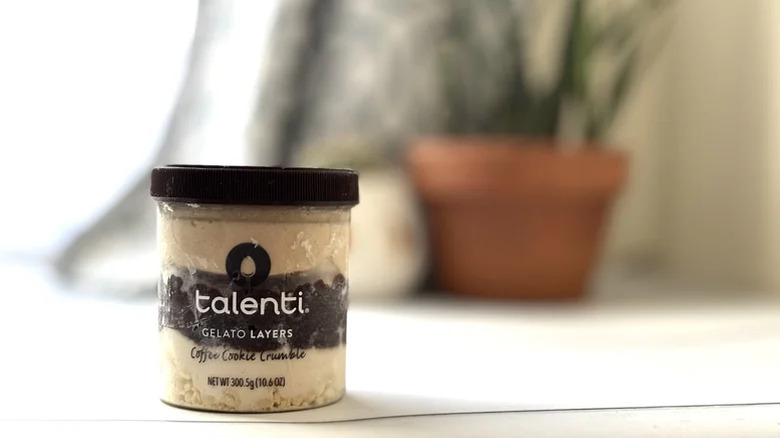 A tub of talenti coffee chocolate chip gelato sits in front of a window