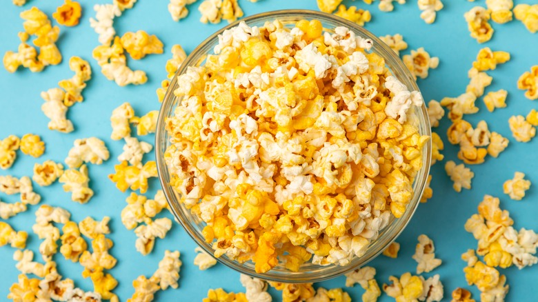 Popcorn spilling out of a glass bowl