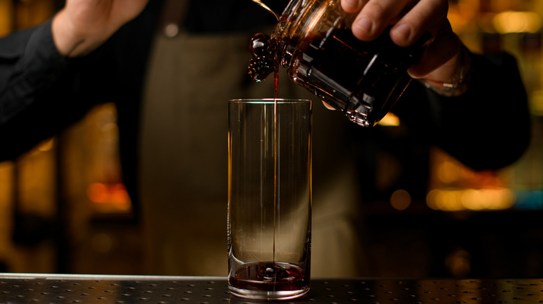 bartender pouring syrup into glass