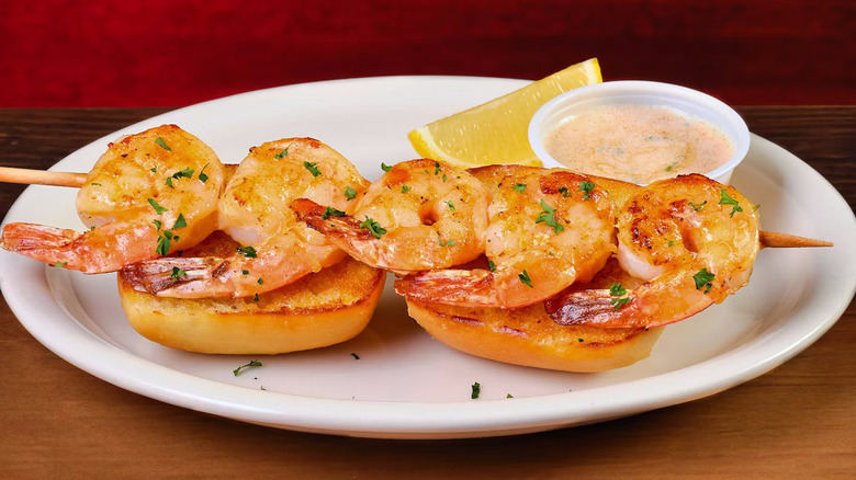 A shrimp skewer on top of two pieces of bread from Texas Roadhouse