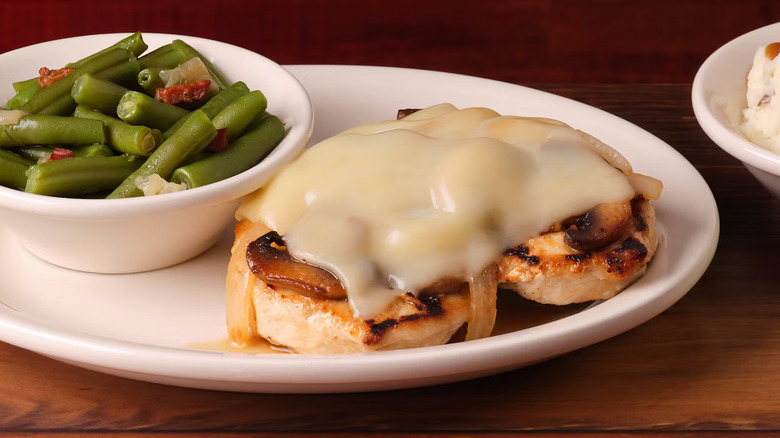 Smothered Chicken on a plate with green beans from Texas Roadhouse