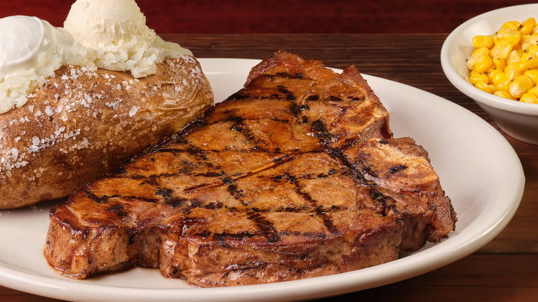 A plate with a porterhouse steak and baked potato from Texas Roadhouse