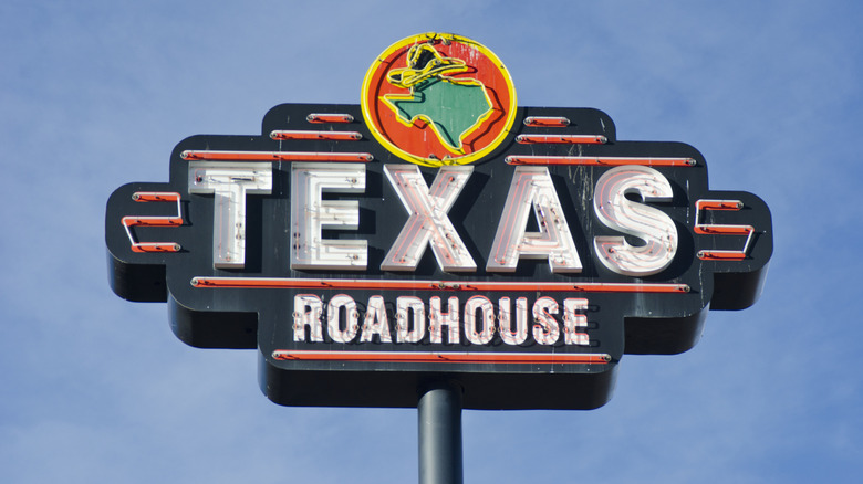 A neon Texas Roadhouse restaurant sign