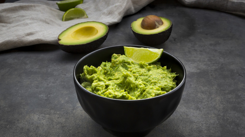 Bowl of guacamole with a wedge of lime