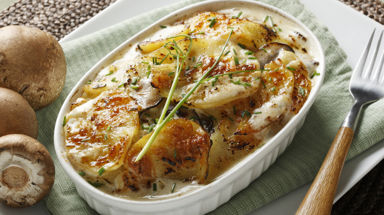 Potato gratin in casserole dish with mushrooms