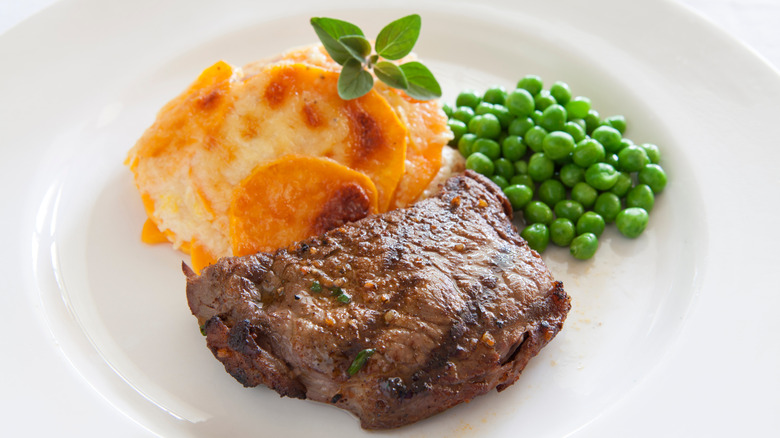 Steak with peas and au gratin potatoes