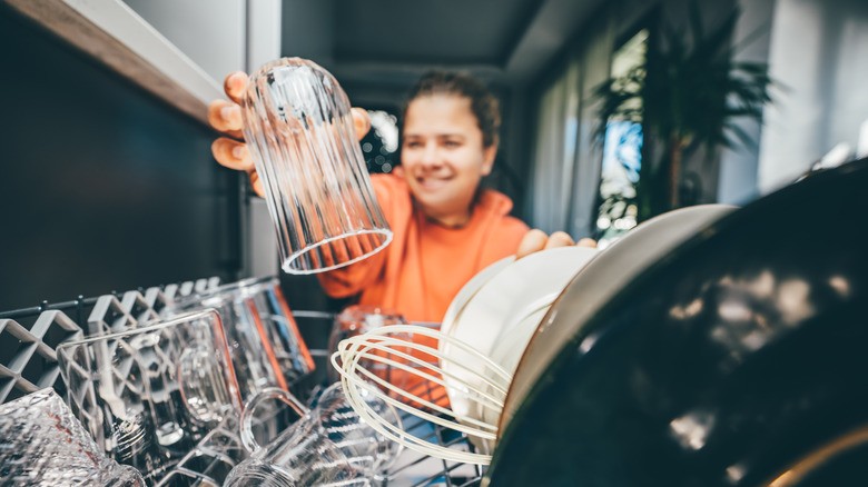 Woman putting dishes in dishwasher