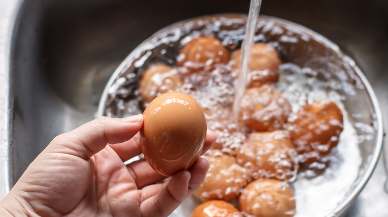 Eggs in a pot under running water