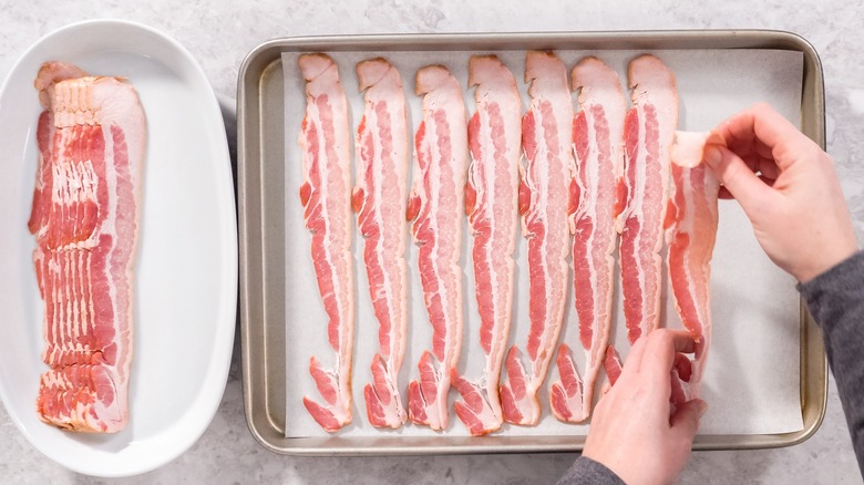 putting bacon on baking sheet