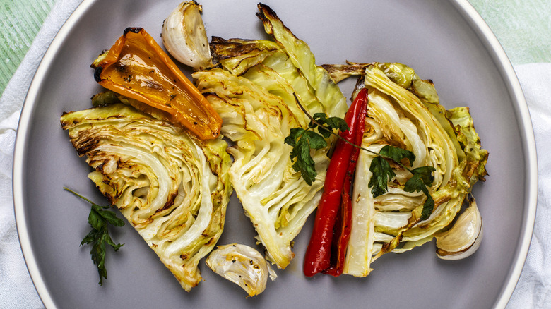 Roasted cabbage on a plate with garlic and peppers