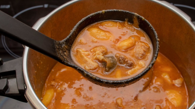 Ladling cooked beans out of a pressure cooker