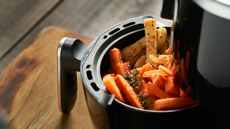 Seasoned carrots and potatoes in an air fryer.
