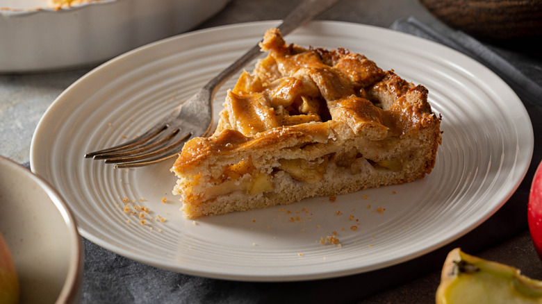 Slice of apple pie on a plate with lattice crust