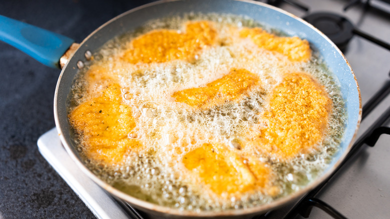 fried fish in hot oil in pan