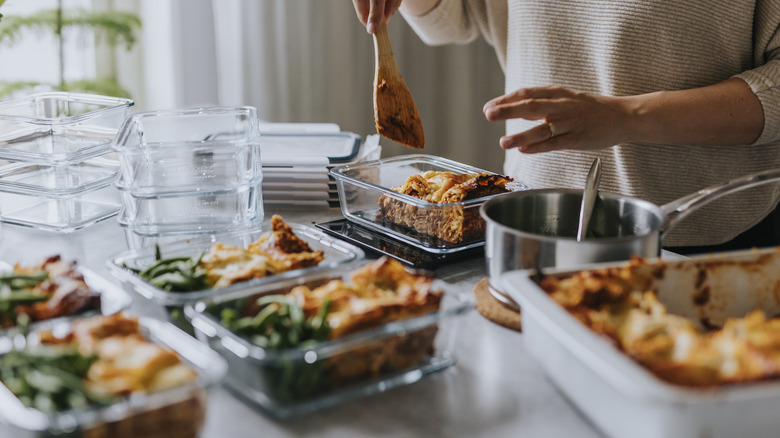 Person portioning lasagna into containers