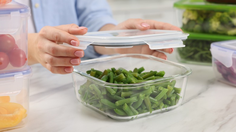 Placing lid on container of green beans