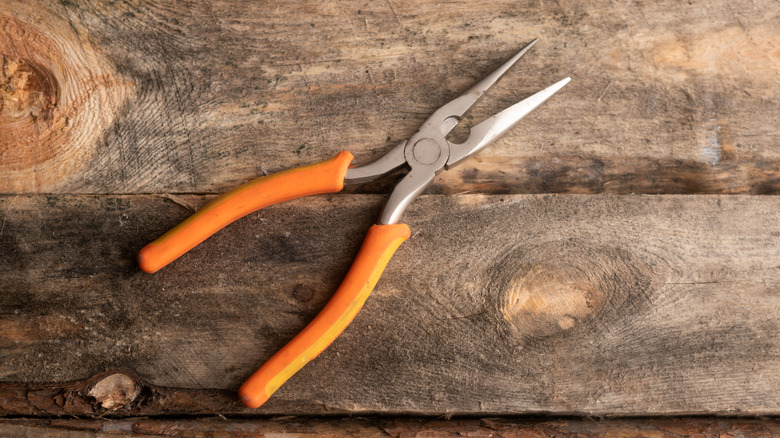 Needle-nosed pliers on wood