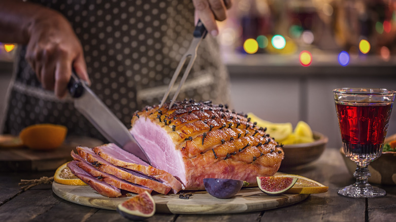 Person carving a ham