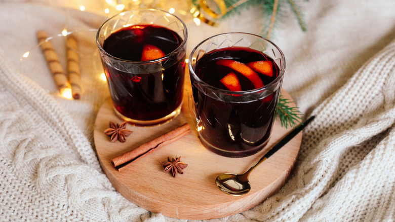 Glasses of mulled wine sit on a circular tray resting on a blanket.