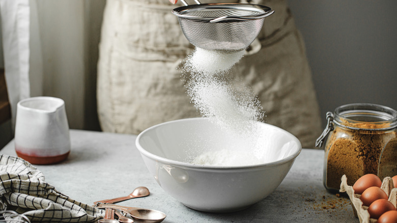 Sifting flour into a bowl