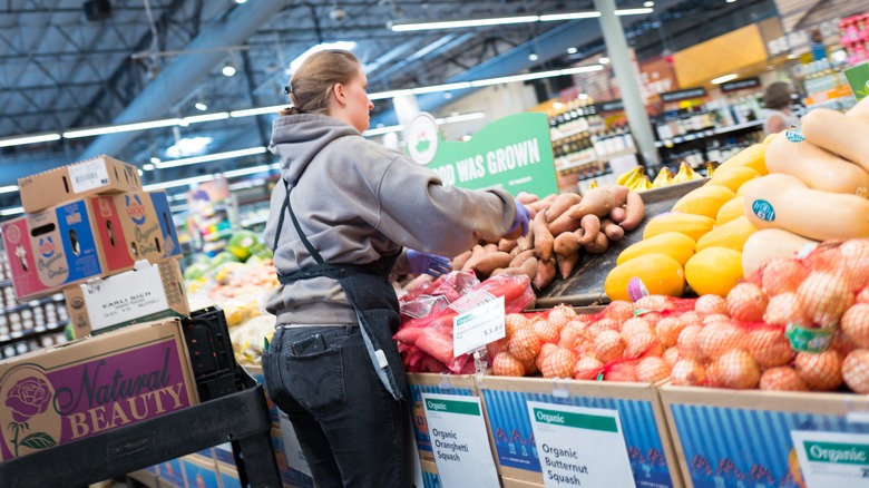 Whole Foods employee organizing produce