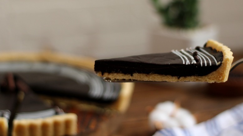 Slice of chocolate tart on a serving utensil