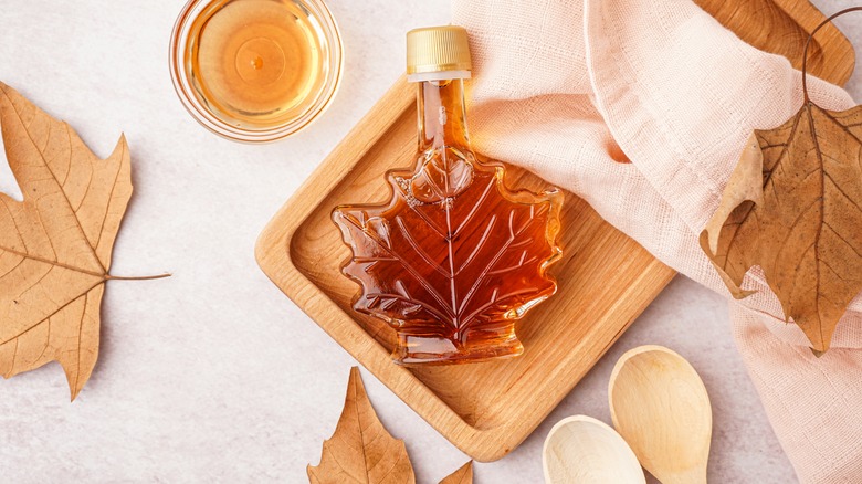 Bottle of maple syrup on a wooden cutting board