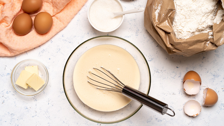 Pancake batter in bowl with eggs and flour