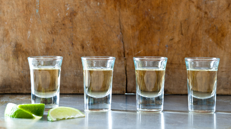 Four shots of tequila with limes