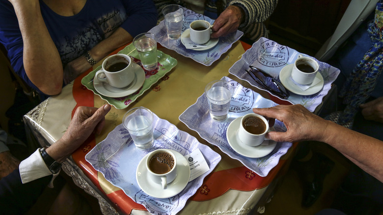 People sharing Greek coffee at a table