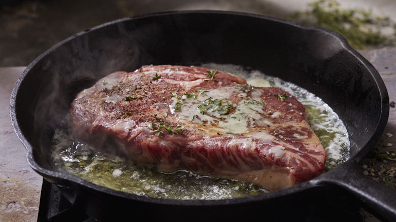 Steak cooking in pan