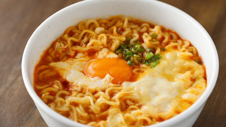 A bowl of ramen with egg and fresh herbs