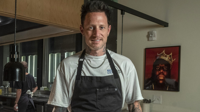 Michael Voltaggio smiles in front of a professional kitchen