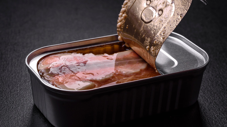 Silver can of salmon with lid peeled back