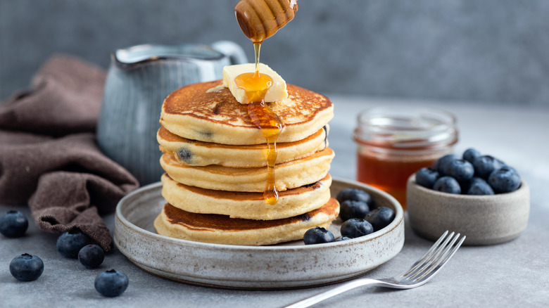 Honey flowing on stack of pancakes