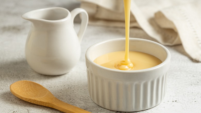 Pouring sweetened condensed milk into ramekin