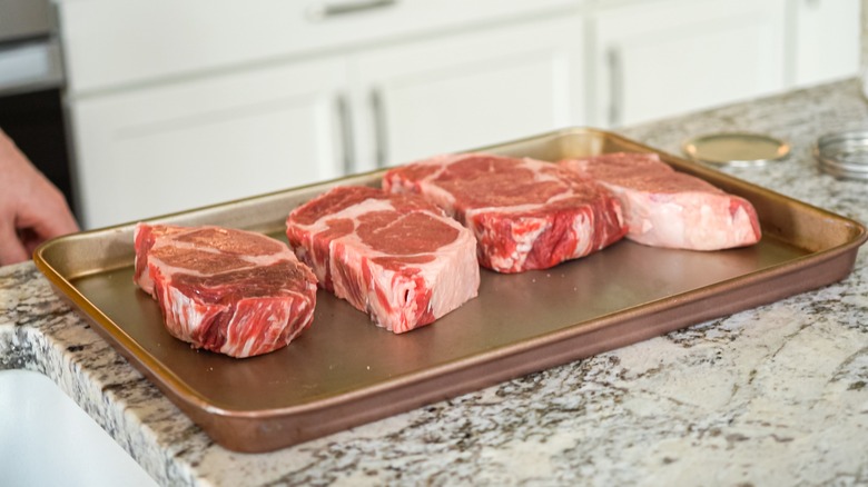 Steaks on a baking sheet