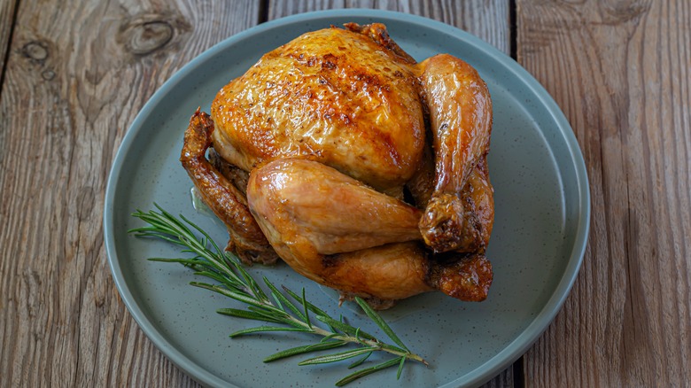 Roasted chicken on a plate with rosemary