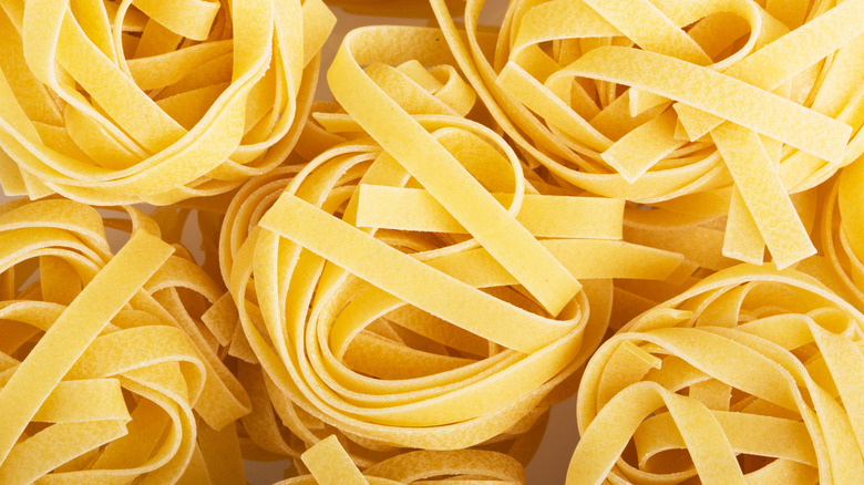 Multiple mounds of dried tagliatelle pasta