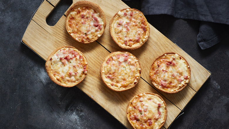 mini pizzas on cutting board