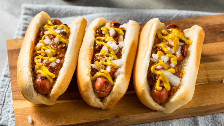 three coney dogs on a cutting board